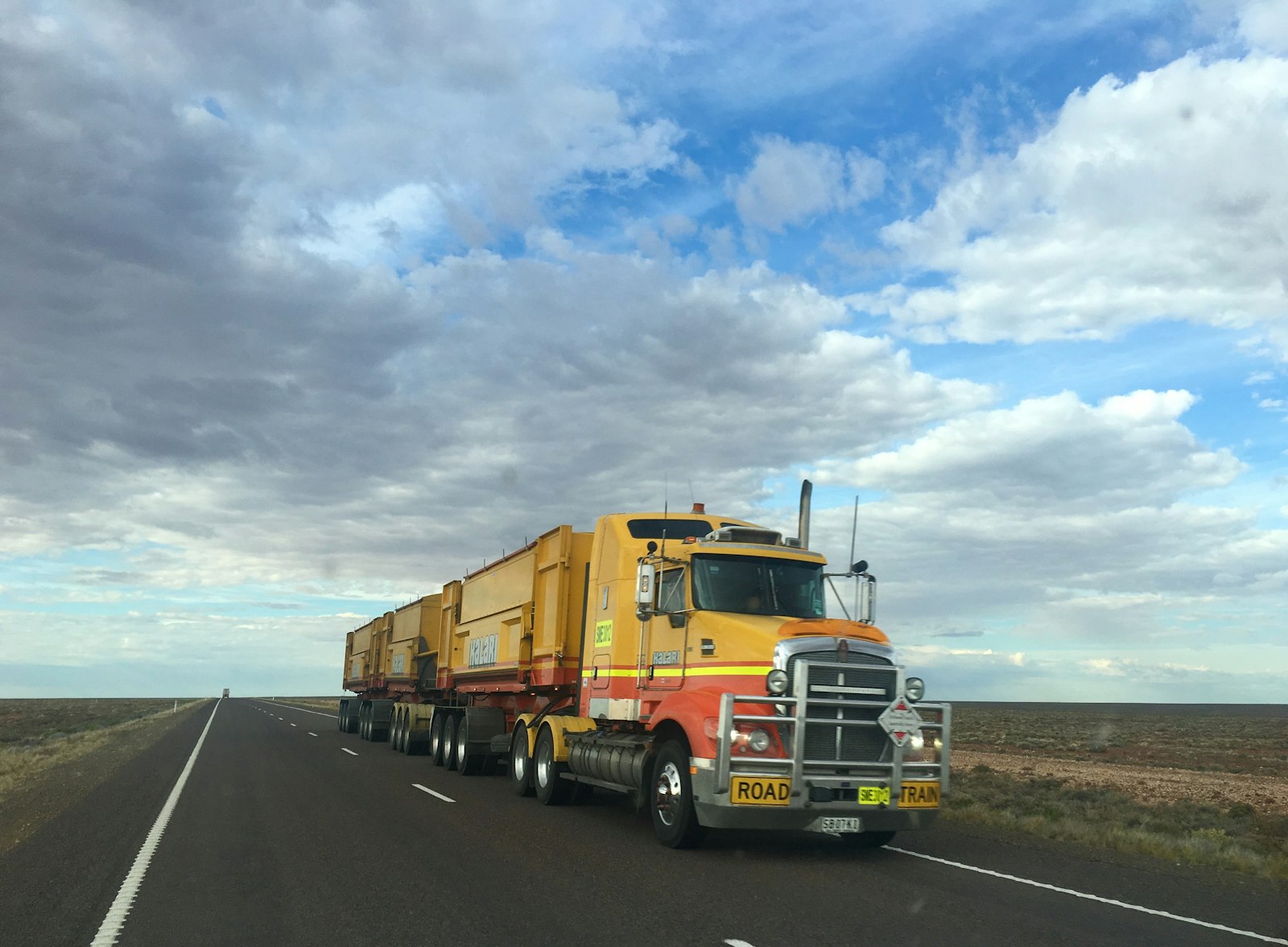 Semi truck hauling freight on a Canadian highway at dusk